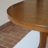 Table à manger ovale vintage en chêne massif, années 80, piètement sculptural en forme de patins, plateau en très bon état avec patine naturelle.