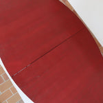 Table à manger ovale en teck avec piètement central sculptural en bois foncé et plateau à teinte rougeâtre, style scandinave vintage, présentée seule et en mise en situation.