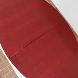 Table à manger ovale en teck avec piètement central sculptural en bois foncé et plateau à teinte rougeâtre, style scandinave vintage, présentée seule et en mise en situation.