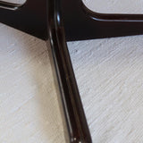 Table à manger ovale en teck avec piètement central sculptural en bois foncé et plateau à teinte rougeâtre, style scandinave vintage, présentée seule et en mise en situation.