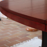 Table à manger ovale en teck avec piètement central sculptural en bois foncé et plateau à teinte rougeâtre, style scandinave vintage, présentée seule et en mise en situation.