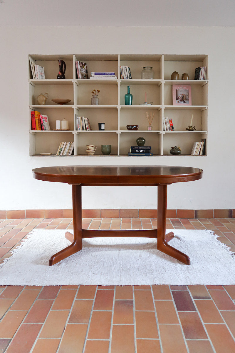 Table à manger ovale en teck avec deux rallonges intégrées, design scandinave des années 60, piètement central en bois.