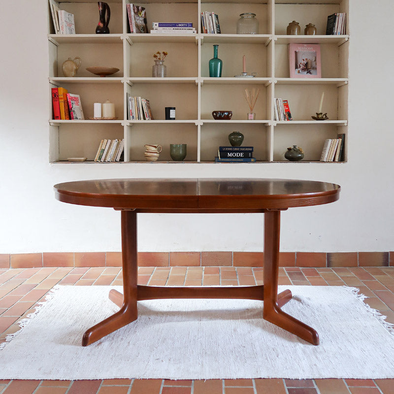Table à manger ovale en teck avec deux rallonges intégrées, design scandinave des années 60, piètement central en bois.