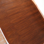 Table à manger ovale en teck avec deux rallonges intégrées, design scandinave des années 60, piètement central en bois.