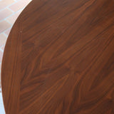 Table à manger ovale en teck avec deux rallonges intégrées, design scandinave des années 60, piètement central en bois.