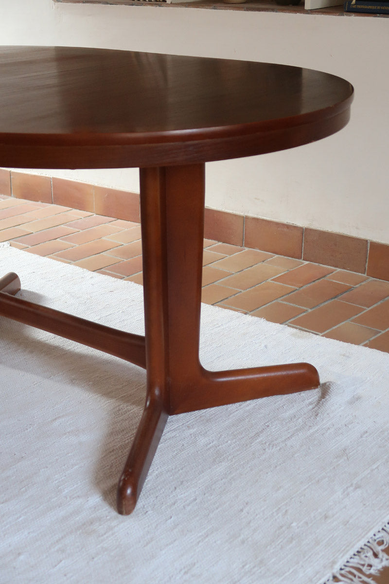 Table à manger ovale en teck avec deux rallonges intégrées, design scandinave des années 60, piètement central en bois.