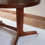 Table à manger ovale en teck avec deux rallonges intégrées, design scandinave des années 60, piètement central en bois.