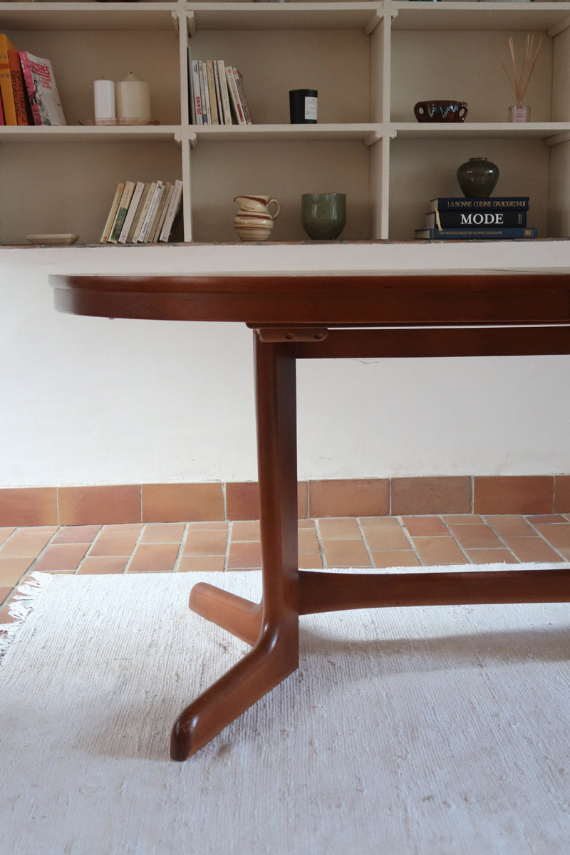 Table à manger ovale en teck avec deux rallonges intégrées, design scandinave des années 60, piètement central en bois.