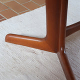 Table à manger ovale en teck avec deux rallonges intégrées, design scandinave des années 60, piètement central en bois.