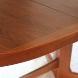 Table à manger ovale en teck avec deux rallonges intégrées, design scandinave des années 60, piètement central en bois.