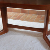 Table à manger ovale en teck avec deux rallonges intégrées, design scandinave des années 60, piètement central en bois.