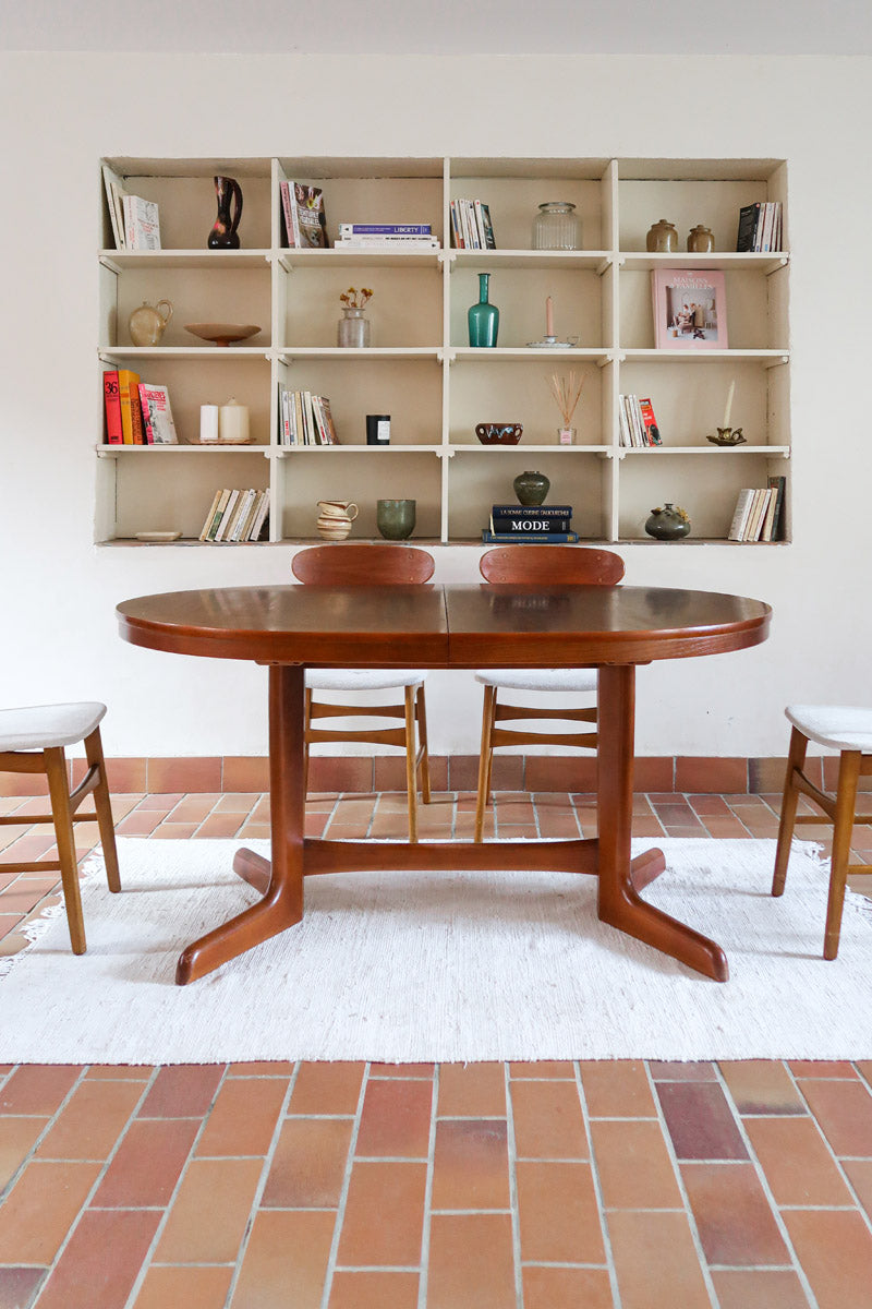 Table à manger ovale en teck avec deux rallonges intégrées, design scandinave des années 60, piètement central en bois.