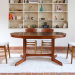 Table à manger ovale en teck avec deux rallonges intégrées, design scandinave des années 60, piètement central en bois.