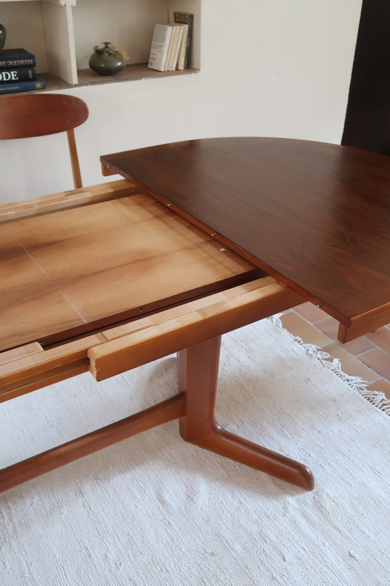 Table à manger ovale en teck avec deux rallonges intégrées, design scandinave des années 60, piètement central en bois.