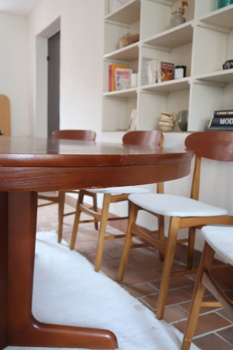 Table à manger ovale en teck avec deux rallonges intégrées, design scandinave des années 60, piètement central en bois.