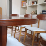 Table à manger ovale en teck avec deux rallonges intégrées, design scandinave des années 60, piètement central en bois.