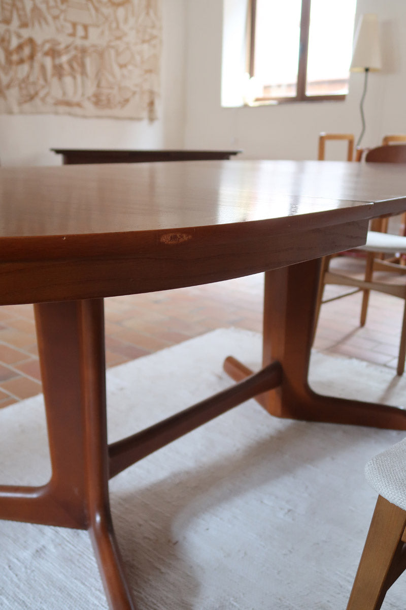 Table à manger ovale en teck avec deux rallonges intégrées, design scandinave des années 60, piètement central en bois.