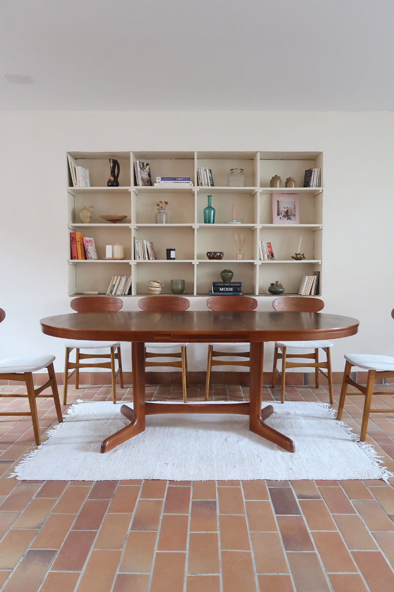 Table à manger ovale en teck avec deux rallonges intégrées, design scandinave des années 60, piètement central en bois.