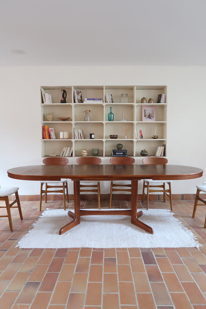 Table à manger ovale en teck avec deux rallonges intégrées, design scandinave des années 60, piètement central en bois.