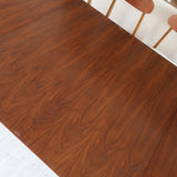 Table à manger ovale en teck avec deux rallonges intégrées, design scandinave des années 60, piètement central en bois.