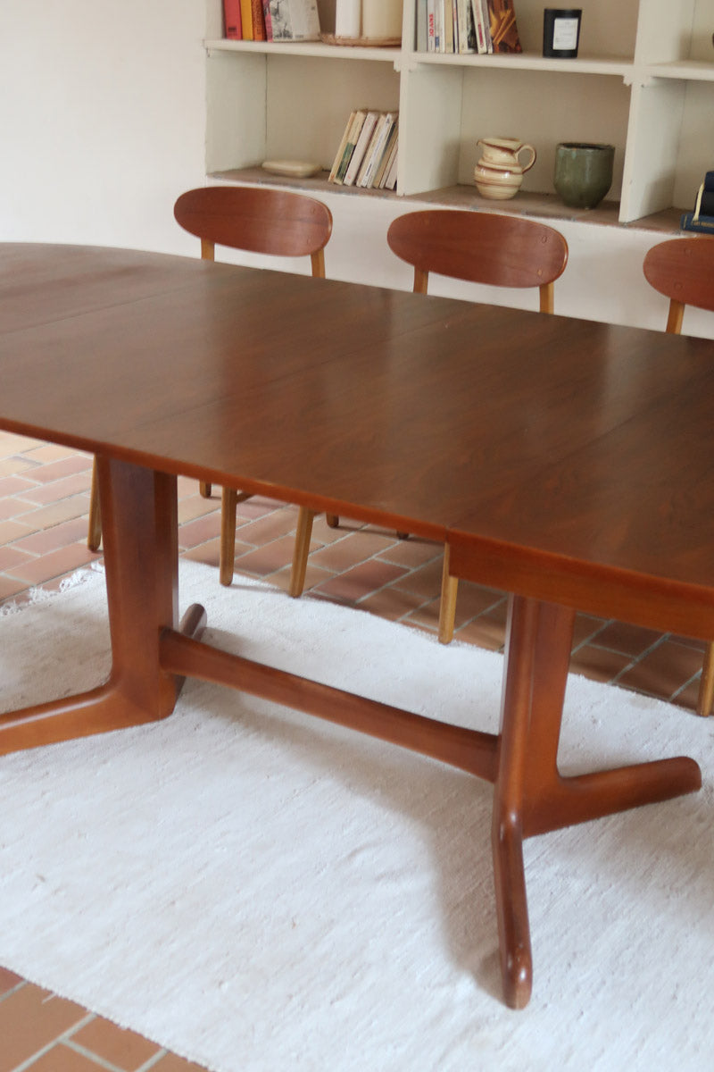 Table à manger ovale en teck avec deux rallonges intégrées, design scandinave des années 60, piètement central en bois.
