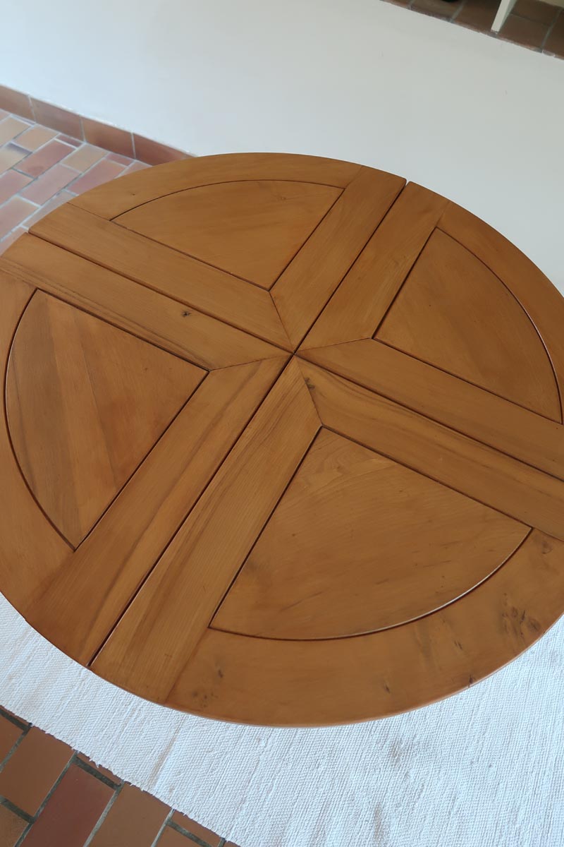 Table ronde extensible en orme massif attribuée à Maison Regain, années 80, plateau à motifs géométriques, rallonge intégrée, patine naturelle.