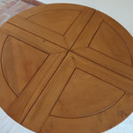 Table ronde extensible en orme massif attribuée à Maison Regain, années 80, plateau à motifs géométriques, rallonge intégrée, patine naturelle.