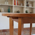 Table ronde extensible en orme massif attribuée à Maison Regain, années 80, plateau à motifs géométriques, rallonge intégrée, patine naturelle.