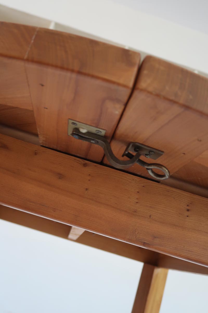 Table ronde extensible en orme massif attribuée à Maison Regain, années 80, plateau à motifs géométriques, rallonge intégrée, patine naturelle.