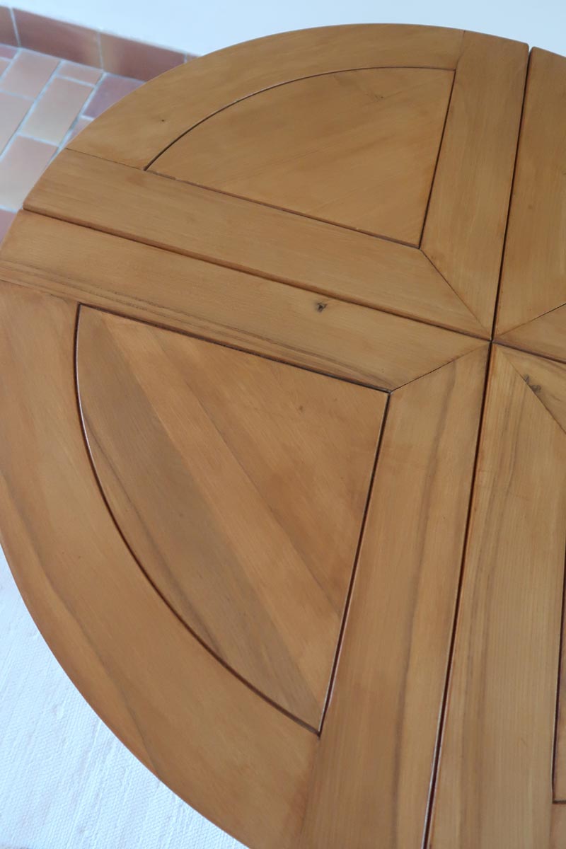 Table ronde extensible en orme massif attribuée à Maison Regain, années 80, plateau à motifs géométriques, rallonge intégrée, patine naturelle.