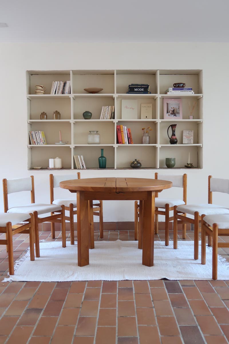 Table ronde extensible en orme massif attribuée à Maison Regain, années 80, plateau à motifs géométriques, rallonge intégrée, patine naturelle.