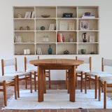 Table ronde extensible en orme massif attribuée à Maison Regain, années 80, plateau à motifs géométriques, rallonge intégrée, patine naturelle.