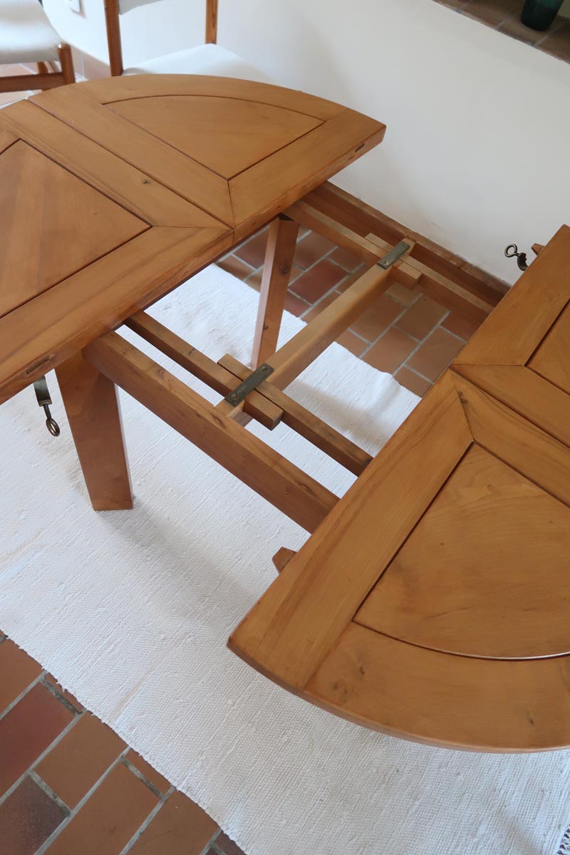 Table ronde extensible en orme massif attribuée à Maison Regain, années 80, plateau à motifs géométriques, rallonge intégrée, patine naturelle.