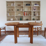 Table ronde extensible en orme massif attribuée à Maison Regain, années 80, plateau à motifs géométriques, rallonge intégrée, patine naturelle.