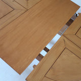 Table ronde extensible en orme massif attribuée à Maison Regain, années 80, plateau à motifs géométriques, rallonge intégrée, patine naturelle.