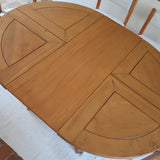 Table ronde extensible en orme massif attribuée à Maison Regain, années 80, plateau à motifs géométriques, rallonge intégrée, patine naturelle.