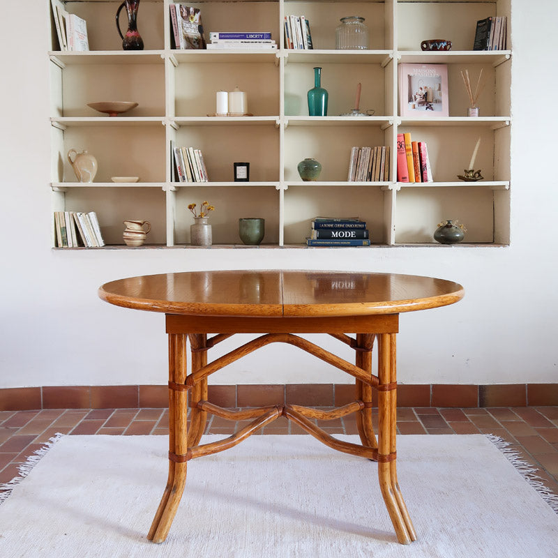 Table à manger ovale extensible bois clair piètement rotin années 70, rallonge centrale, ligatures cuir, jusqu'à 8 couverts