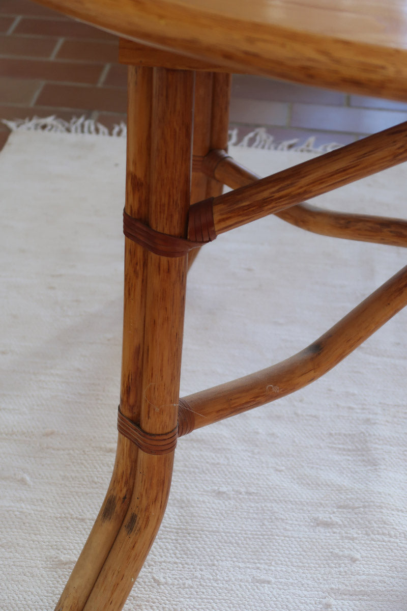 Table à manger ovale extensible bois clair piètement rotin années 70, rallonge centrale, ligatures cuir, jusqu'à 8 couverts