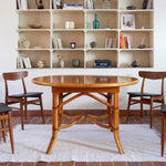 Table à manger ovale extensible bois clair piètement rotin années 70, rallonge centrale, ligatures cuir, jusqu'à 8 couverts