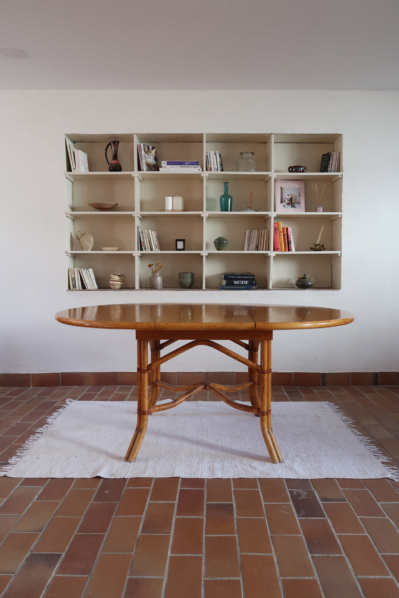 Table à manger ovale extensible bois clair piètement rotin années 70, rallonge centrale, ligatures cuir, jusqu'à 8 couverts