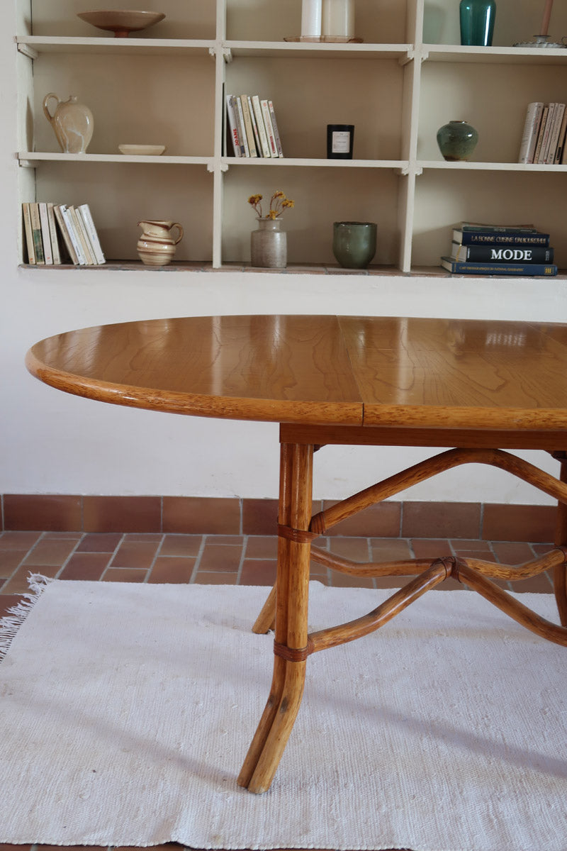 Table à manger ovale extensible bois clair piètement rotin années 70, rallonge centrale, ligatures cuir, jusqu'à 8 couverts
