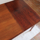 Table à rallonge scandinave en palissandre années 60, plateau veinage flamboyant, pieds fuseau, structure bois clair, 8 couverts