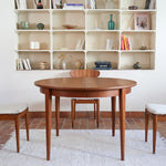 Table à manger ronde extensible vintage en teck miel, pieds fuseau, deux rallonges jusqu'à douze couverts, style scandinave fabrication française années 60