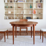 Table à manger ronde extensible vintage en teck miel, pieds fuseau, deux rallonges jusqu'à douze couverts, style scandinave fabrication française années 60