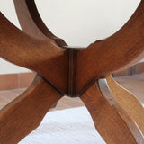 Table ronde vintage à rallonge en chêne massif éditée par Lübke, Allemagne années 60, estampille d'origine sous le plateau, piétement central à quatre jambes plates croisées en X réunies par un moyeu rond, allonge centrale