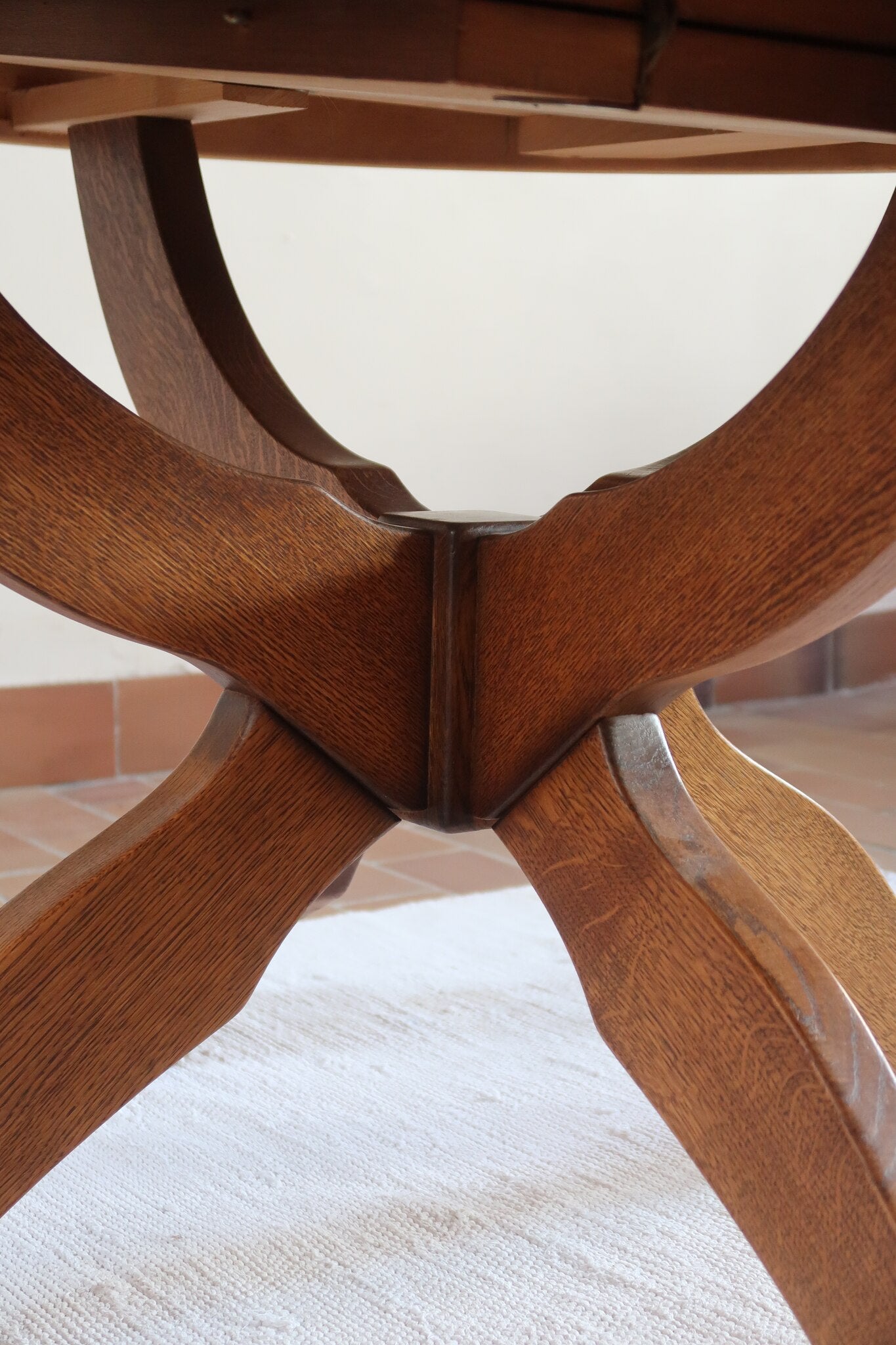 Table ronde vintage à rallonge en chêne massif éditée par Lübke, Allemagne années 60, estampille d'origine sous le plateau, piétement central à quatre jambes plates croisées en X réunies par un moyeu rond, allonge centrale