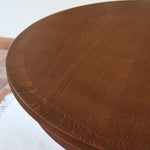 Table ronde vintage à rallonge en chêne massif éditée par Lübke, Allemagne années 60, estampille d'origine sous le plateau, piétement central à quatre jambes plates croisées en X réunies par un moyeu rond, allonge centrale