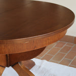 Table ronde vintage à rallonge en chêne massif éditée par Lübke, Allemagne années 60, estampille d'origine sous le plateau, piétement central à quatre jambes plates croisées en X réunies par un moyeu rond, allonge centrale