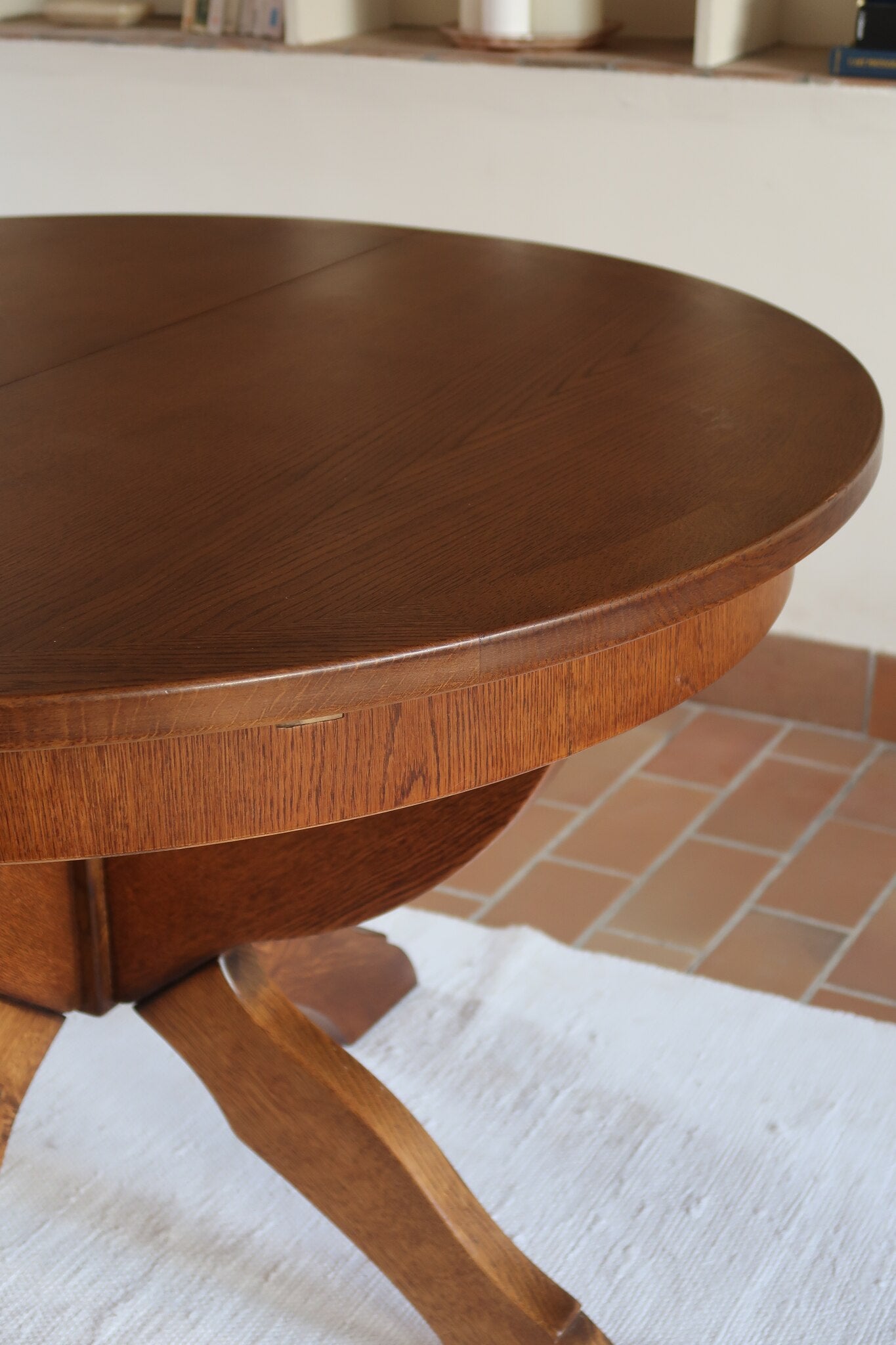 Table ronde vintage à rallonge en chêne massif éditée par Lübke, Allemagne années 60, estampille d'origine sous le plateau, piétement central à quatre jambes plates croisées en X réunies par un moyeu rond, allonge centrale