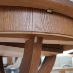 Table ronde vintage à rallonge en chêne massif éditée par Lübke, Allemagne années 60, estampille d'origine sous le plateau, piétement central à quatre jambes plates croisées en X réunies par un moyeu rond, allonge centrale